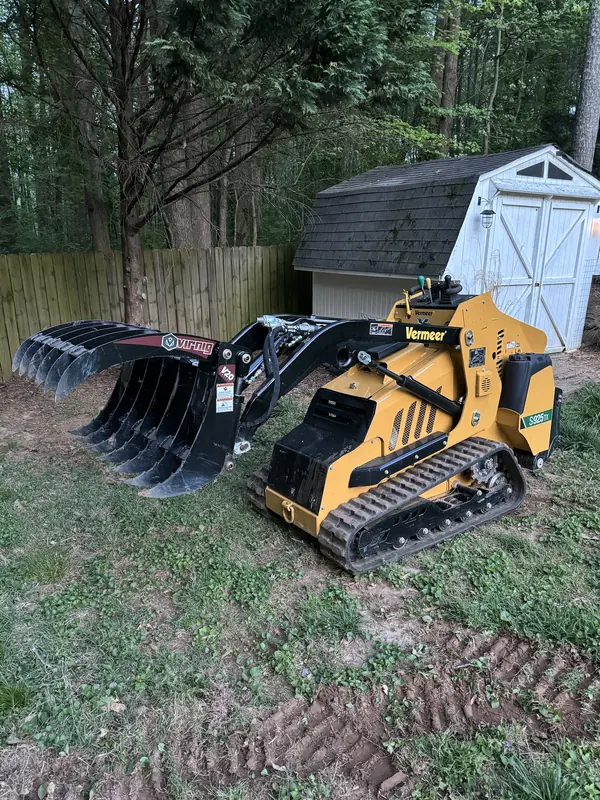 Vermeer S925TX mini skid steer with a root grapple